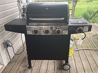 Front view of Tera Gear gas BBQ grill showing three control knobs and side burners.
