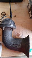 Side view of vintage Spartan air horn showing embossed brand and country of origin 'SPARTAN MADE IN USA' on metal body.