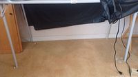Photo of the foldable table showing full length of legs and part of tabletop with beige carpet background.