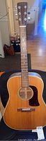 Front view of full dreadnought acoustic guitar resting on chair