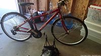 Side view of the full red Raleigh Detour bike showing the frame size, wheels, gear system, seat, fenders and kickstand