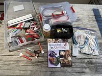 Overview of quilting and sewing supplies including tools, brushes, a pincushion, quilting book, templates, and storage boxes.