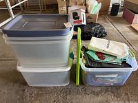 Photo showing two large plastic totes stacked and one smaller plastic tote filled with various reusable grocery bags and plastic totes.
