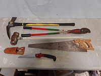 All tools laid out on a white table showing the variety in size and type