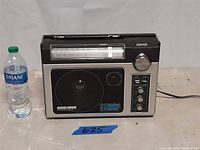Front view of the General Electric Superadio II radio next to a water bottle for scale.
