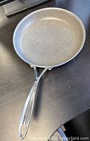 Top and angled view of 10-inch gray fry pan showing textured nonstick surface and metal ergonomic handle.