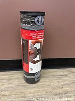 Rolled New Balance fitness mat in original packaging with visible label and branding, black color.