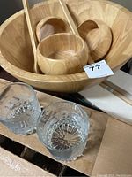 Wooden salad bowl set showing large and smaller bowl with wooden salad servers and two clear drinking glasses marked Vancouver BC in front.