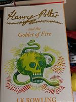 Cover of 'Harry Potter and the Goblet of Fire' showing green skull with a snake wrapped around it, golden title, author name 'J.K. Rowling'