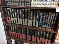 Shelf with Encyclopedia Britannica and World Book Encyclopedia volumes arranged neatly.