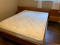 Overall angled view of teak bed frame and mattress