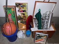 Basketball, blue scooter, boxed mini croquet set, boxed badminton set, ice chest with cups, umbrella, bubble container shown in single view.