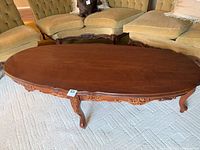 Full view of the oval wooden coffee table in a living room setting.