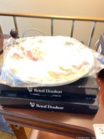 Dinner plates stacked in original Royal Doulton box, plates wrapped in plastic.