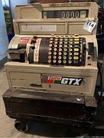 Front view of the vintage Castrol branded cash register showing keys, display, and base.