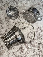 All three items grouped on surface: pickle holder basket, vanity dish, and glass jar with silver lid.