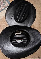 Two black Cavender's cowboy hats shown top down and from inside, highlighting the brand label and classic western crease crown shape, all in new condition.