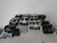 Overview of multiple camera bodies and accessories on table