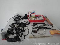 Wide view of assorted Pentax Auto 110 SLR camera accessories, cable cords, lens filters, and a red organizing tray