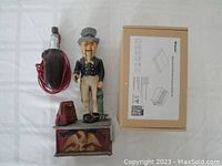 Vintage cast-iron Uncle Sam bank with eagle motif base, Uncle Sam figure, broken ankle and a vintage electric tool with red cord plus a box of Breezesmile wireless switch kits