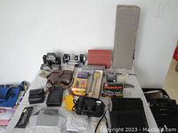 Overview of camera accessories including cases, lens hoods, boxed items, and focusing rail.