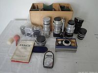 Overview of camera body, lenses, wooden case, light meter, blower, booklet and adapter