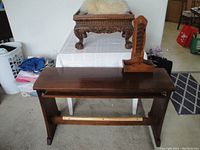 Full view of the lot showing solid wood piano bench, ornate carved foot stool with wool pillow on top, and wooden letter sorter placed on bench.