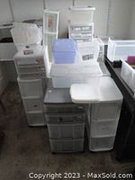 Overview of multiple stacked plastic storage drawers and bins of various sizes