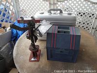 Mayville Engineering Company MEC 600 Jr shotgun shell reloading press with Halliburton metal case and Rolykit parts organizer on a round table.