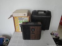 Set of three slide projectors with boxes and carrying case visible.