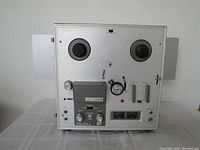 Front view of the Akai 1710W reel to reel stereo tape recorder showing the tape spools, control knobs, meters, and switches on metal face panel.