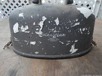 Photo of the weathered black metal carrying case showing paint chipping and partial logo