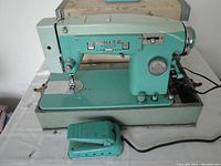 Front side of the vintage White sewing machine model 1563 with foot pedal and case visible.