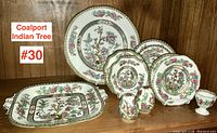 Full set of 11 antique Coalport Indian Tree pieces displayed on shelf including plates, tray, salt and pepper shakers, and egg cup.
