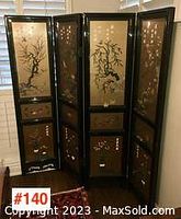 Front view of 4-panel Asian wooden room divider with black lacquer frame and floral stone carved panels under glass.