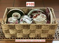 Basket filled with vintage teacups and saucers, arranged vertically, showing variety of colors and patterns