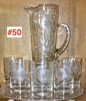Full set showing the glass pitcher and five juice glasses arranged on wooden surface