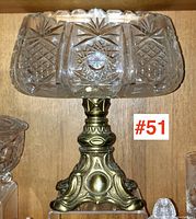 Front view of cut crystal bowl with detailed geometric patterns and ornate plated metal pedestal.