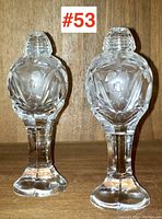 Front view of the pair of tall crystal salt and pepper shakers showing the etched floral pattern and faceted pedestal base.