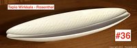 Top-down view showing the elongated leaf form and embossed dotted texture of the white serving dish.