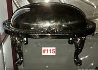 Front view of the butter dish with hinged domed lid closed, showing tarnish and ornate legs