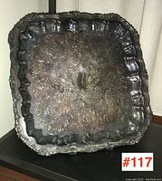 Full front view of the square silver plate serving tray showing the embossed pattern and raised scalloped edge