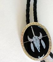 Close-up of the black oval stone centerpiece with grey etched steer skull design and textured silver-tone bezel.