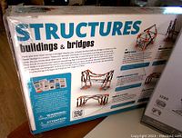 Back of unopened box showing multiple bridge and building models and educational text describing the set and its STEM learning benefits.