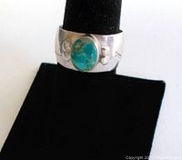 Front view of vintage sterling silver wide band ring with oval natural Kingman turquoise stone mounted in center.