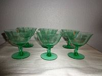 Front angle view showing 6 green glass cups with vertical ribbed glass pattern, arranged in two rows of three.