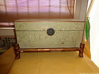 Full view of the rectangular decorative box showing embossed floral pattern, bamboo style stand, and metal clasp.