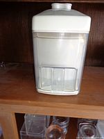 Front view of Moulinex electrical juicer showing white body and clear juice container with pulp compartment below.