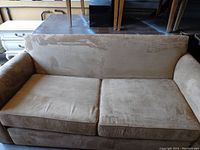 Full view of the brown upholstered sofa bed showing the seating and armrests.