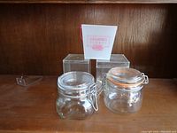 Display of the glass storage jar and two plastic storage boxes on wooden shelf, showing overall set.